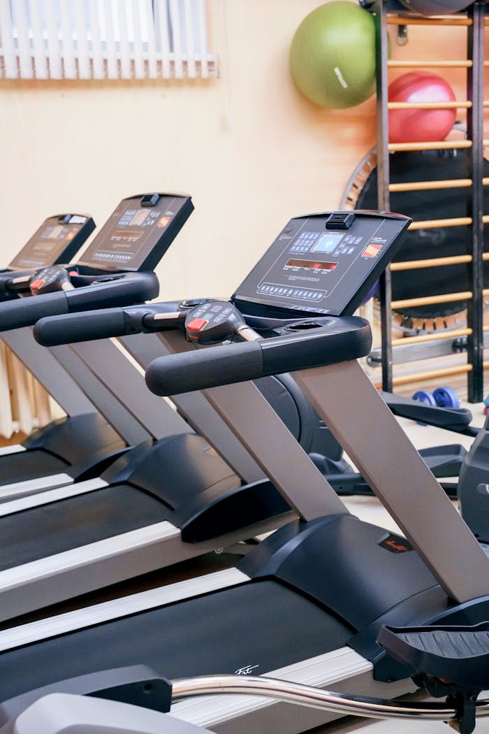 Row of treadmills in a contemporary gym setting for cardio workouts and physical fitness.